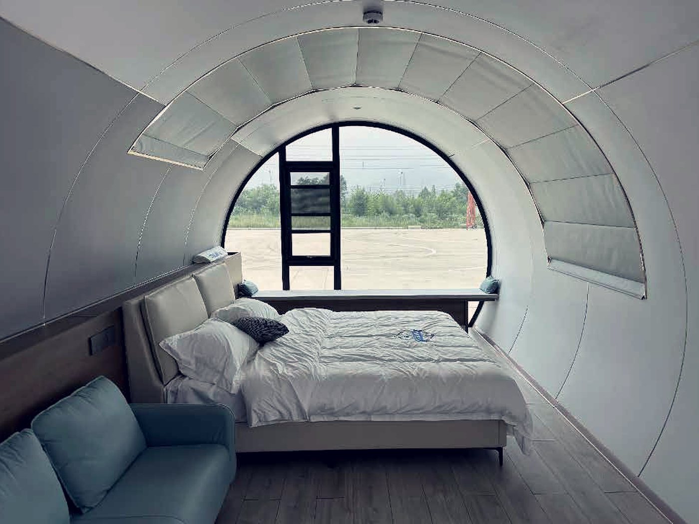 Capsule interior: bed, seating, round window
