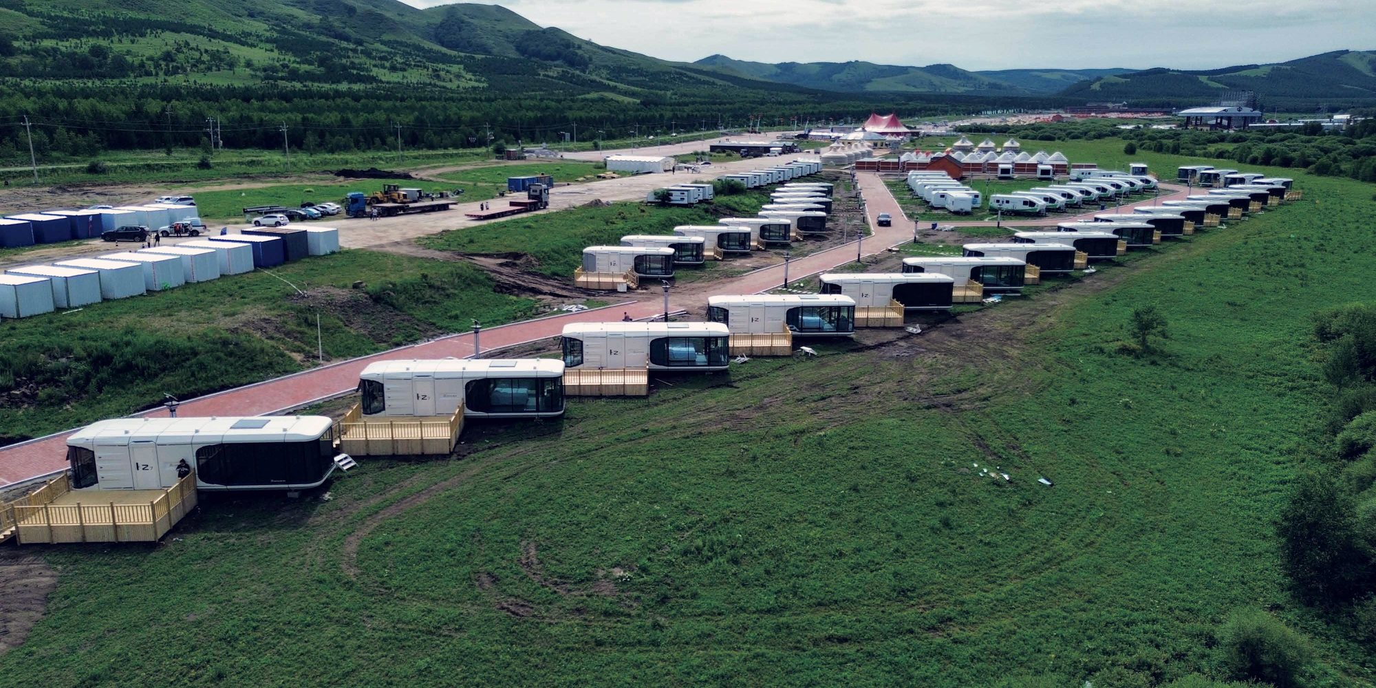 Rows of modular accommodation units across a construction site plateau